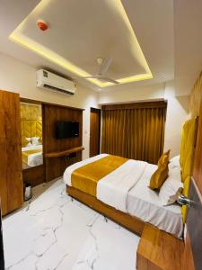 a hotel room with a bed and a television at Hotel Paramount Villa in Gandhinagar