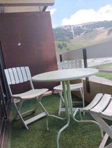 d'une table et de chaises sur un balcon avec vue. dans l'établissement Chamrousse - Résidence Eterlou, à Chamrousse