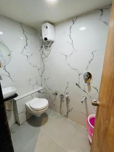 a bathroom with a toilet and a sink at Hotel Paramount Villa in Gandhinagar