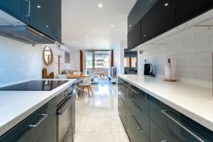 una cocina con encimeras blancas y armarios azules en Villa María, en La Cala de Mijas