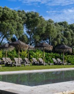 a group of lounge chairs and umbrellas next to a pool at Nomaddicts in Cádiz