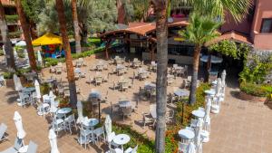 an outdoor patio with tables and chairs and palm trees at Sundia By Liberty Suncity in Oludeniz