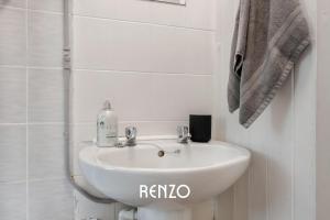 a bathroom with a white sink and a towel at Vibrant and Cosy 3-Bed Home in Nottingham by Renzo, Perfect for Contractors, Free Parking! in Beeston