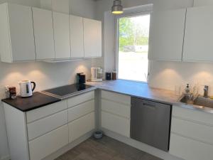 a kitchen with white cabinets and a sink and a window at Flexsleep&living in Lystrup