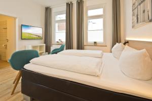 una habitación de hotel con 2 camas y una silla en Haus Menno Janssen - Doppelzimmer, en Norderney
