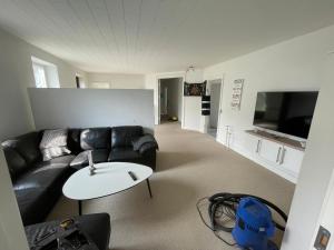 a living room with a black couch and a table at Flexsleep&living in Lystrup