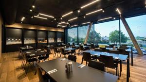 a restaurant with tables and chairs and large windows at ABA Apartments in Olomouc