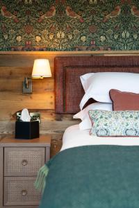 a bedroom with two beds and a nightstand with a lamp at Queens Head Inn & Restaurant in Hawkshead