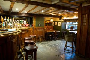 a bar with a bunch of stools in a room at Queens Head Inn & Restaurant in Hawkshead