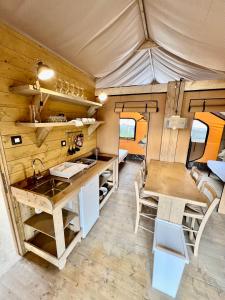 uma cozinha e área de jantar de uma pequena caravana em Glamping Camping Rivabella em Lecco