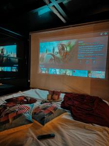 a bed with two pillows and a projection screen at Northland Bungalows in Çayırdüzü