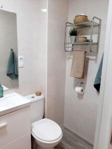 a white bathroom with a toilet and a sink at Confortable apartamento en Elche in Elche