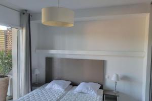 a bedroom with a white bed and a large window at appartement pont du Gard, Remoulins in Remoulins