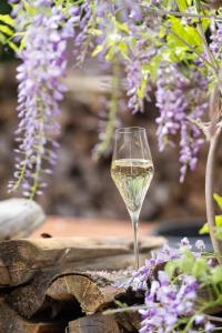 a glass of white wine sitting next to purple flowers at ALPENLIEBE Design Hotel in Inzell