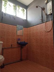 a bathroom with a sink and a shower at Greenleaf Guesthouse in Jerantut