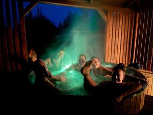 a group of men sitting in a hot tub at Blu Raj - domy w Sudetach in Głuszyca