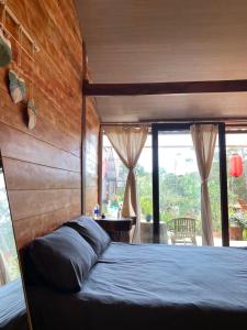 a bedroom with a bed with a wooden head board at Đồi Gió Hú Homestay & Coffee - Măng Đen in Kon Tum