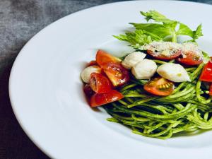 a white plate with a salad with tomatoes and vegetables at Hotel Wing International Premium Tokyo Yotsuya in Tokyo