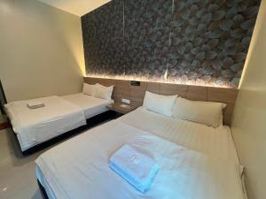 a hotel room with two beds and a wall at Gebeng Industrial Park Budget Hotel in Kuantan