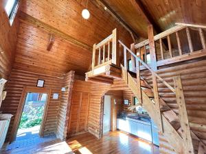 a wooden cabin with a staircase in the ceiling at Tokashiki Guest House in Tokashiki