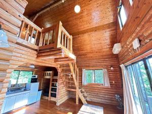 a log cabin with a spiral staircase in the ceiling at Tokashiki Guest House in Tokashiki