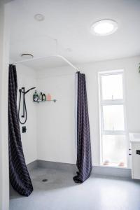 a bathroom with black curtains and a window at Restful stay on Geraldine Street Suburban Beauty in Christchurch