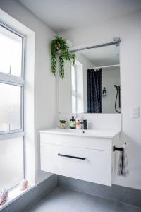 a white bathroom with a sink and a mirror at Restful stay on Geraldine Street Suburban Beauty in Christchurch +14 photos