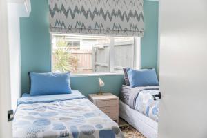 a bedroom with two beds and a window at Restful stay on Geraldine Street Suburban Beauty in Christchurch