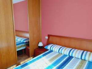 Dormitorio pequeño con cama y espejo en Tenorio-Río Oja, en Ezcaray