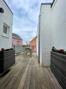 a wooden deck with a table on a balcony at Cosy apartment Airport Brussels with terrace in Zaventem