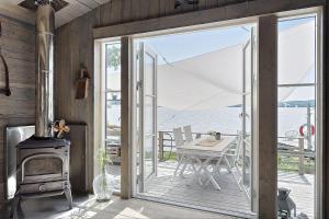 eine offene Tür zu einer Terrasse mit einem Herd und einem Tisch in der Unterkunft Your Own Island Near Stockholm in Söderala