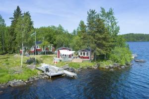 uma casa na margem de um lago com uma doca em Your Own Island Near Stockholm em Söderala
