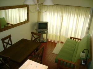 a living room with a table and a television at Apartamento Del Mar in Mar del Plata