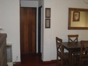 a dining room with a table and a wooden door at Apartamento Del Mar in Mar del Plata