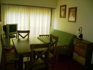 a living room with a table and a green couch at Apartamento Del Mar in Mar del Plata