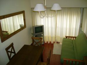 sala de estar con sofá y TV en Apartamento Del Mar en Mar del Plata