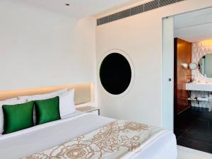 a bedroom with a large white bed with green pillows at The Park Hyderabad, Banjara Hills near Hussain Sagar Lake in Hyderabad