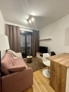 uma sala de estar com um sofá e uma secretária em 1 bedroom cosy apartment em Tivat