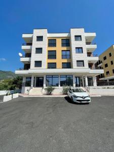 um carro branco estacionado em frente a um edifício em 1 bedroom cosy apartment em Tivat