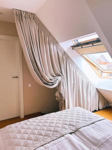 um quarto com uma janela e uma cama de dossel em Apartamentai Juodkrantėje Saulės smūgis 2B 65 em Juodkrantė