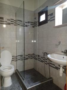 La salle de bains est pourvue de toilettes et d'un lavabo. dans l'établissement Guesthouse Mythos, à Órma