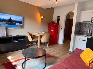 Il comprend une cuisine équipée d'une petite table et d'un réfrigérateur rouge. dans l'établissement Apartment M - Zell am See, à Zell am See