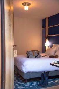 a hotel room with a bed with a backpack on it at Domaine Les Lanternes in Saint-Cyr-au-Mont-dʼOr