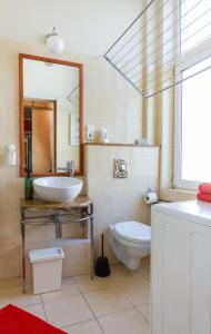 a bathroom with a sink and a toilet and a mirror at Badepest Apartment Budapest in Budapest