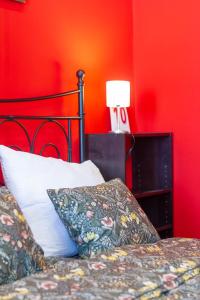 1 dormitorio con cama y pared roja en Badepest Apartment Budapest, en Budapest