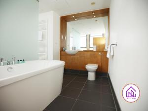 a bathroom with a tub and a sink and a toilet at BS2 Lofts, Monthly Disc, Contractors, Central in Bristol