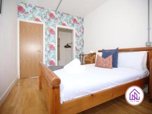 a bedroom with a wooden bed with white sheets at BS2 Lofts, Monthly Disc, Contractors, Central in Bristol