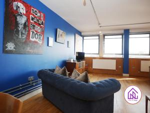 a living room with a couch and a blue wall at BS2 Lofts, Monthly Disc, Contractors, Central in Bristol