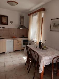 a kitchen with a table and some bottles of wine at Guest House Lucijo in Vrboska