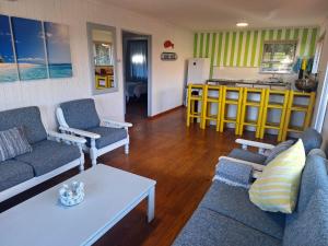 Una sala de estar con dos sofás y una cocina. en The Dunes Villa 11, en Plettenberg Bay